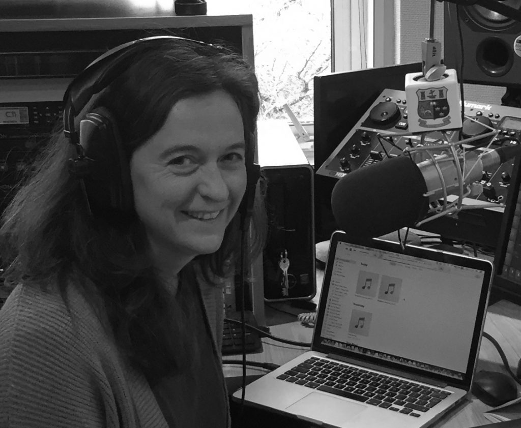 A black and white shot of Abigail Joffe in studio at the radio station